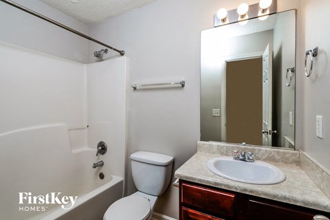 a bathroom with a toilet and a sink and a mirror