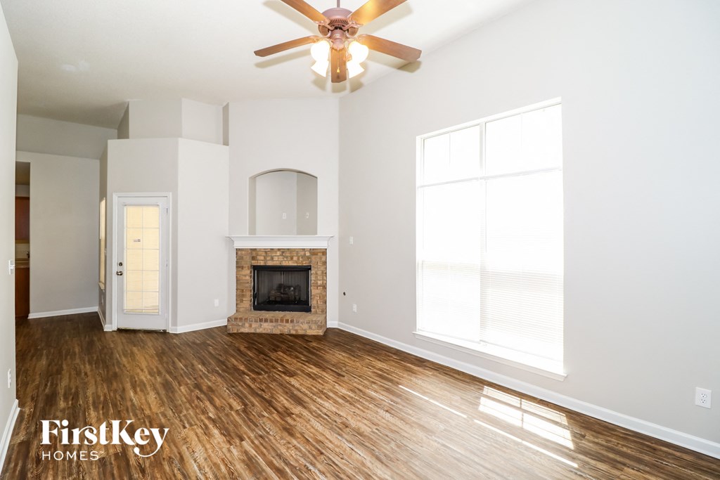 a living room with a fireplace and a ceiling fan