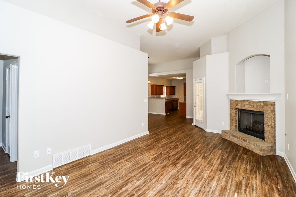 a living room with a fireplace and a ceiling fan