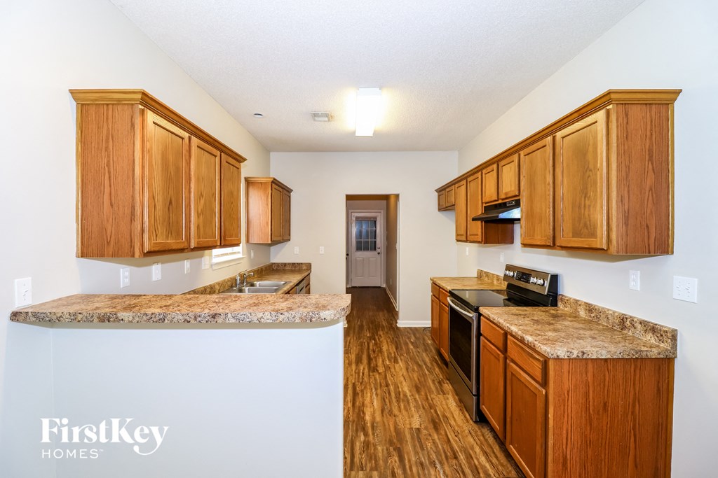 a kitchen with wood flooring and granite counter tops