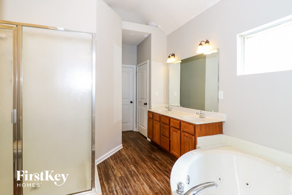 a bathroom with a tub and a sink and a shower