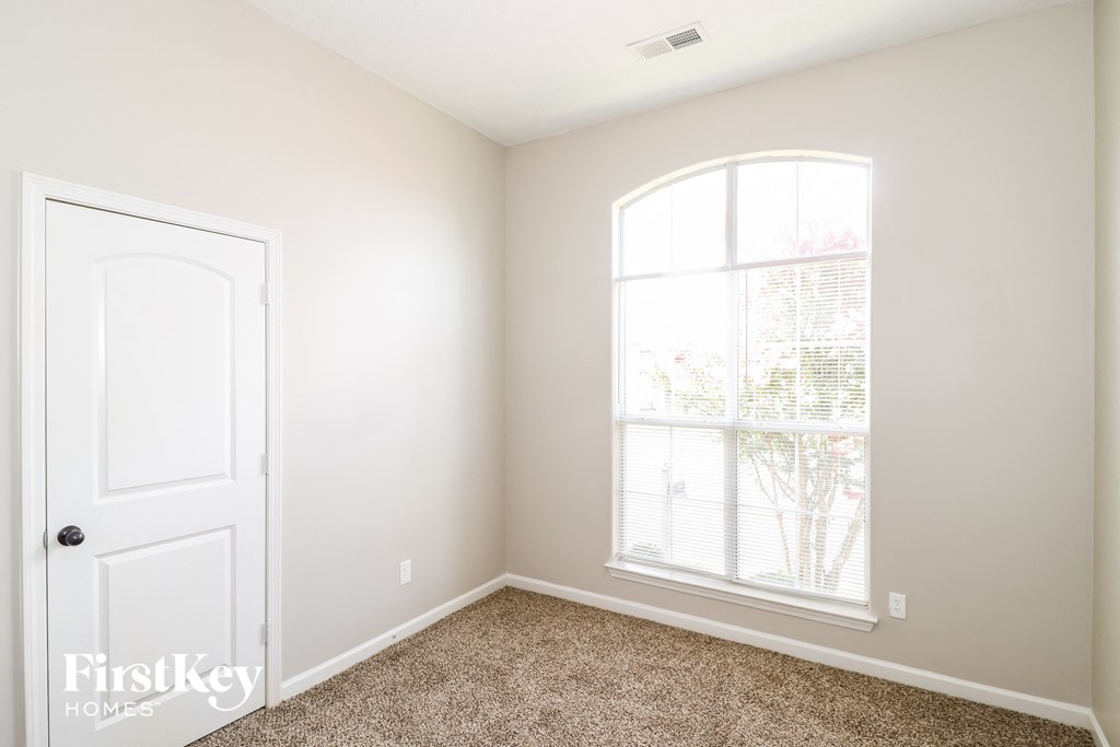a bedroom with a white door and a window