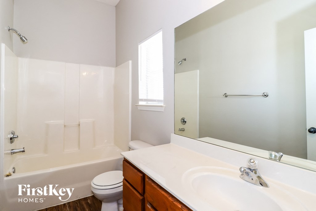 a bathroom with a large mirror and a sink and a toilet