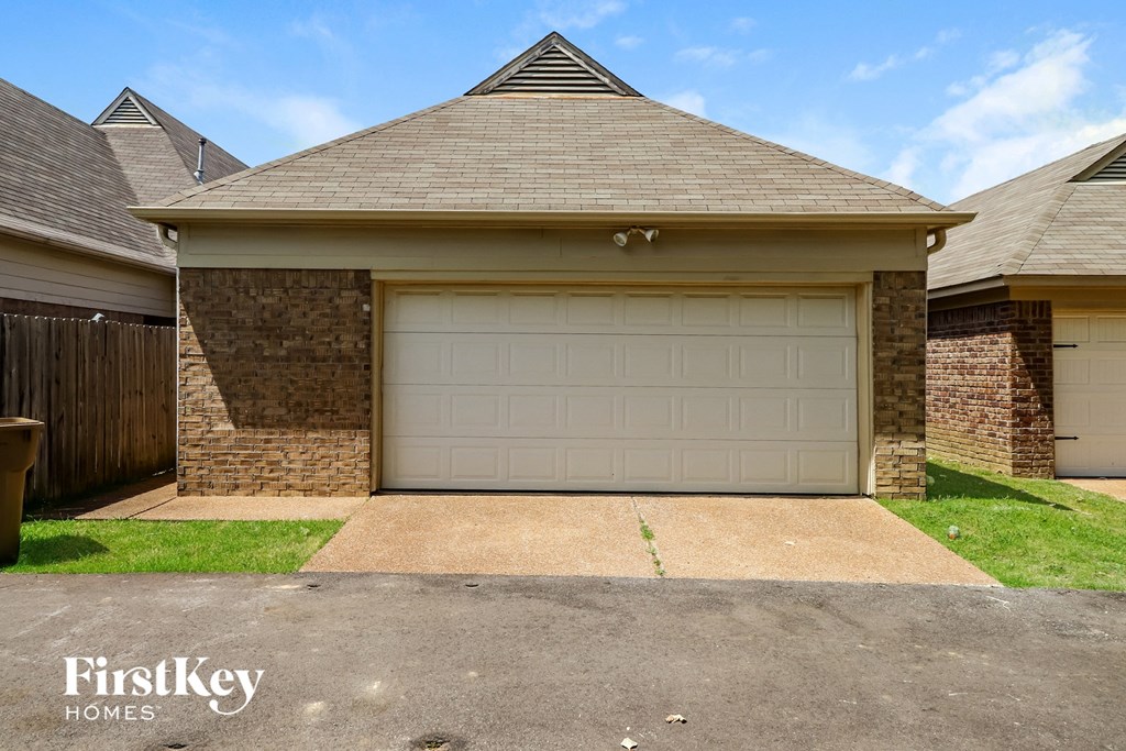 a white garage door in front of a brick house