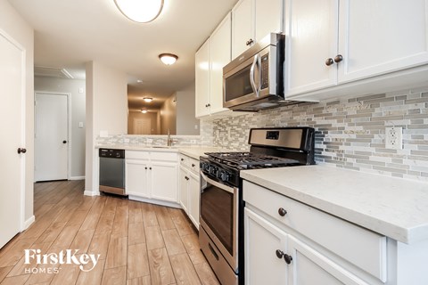 A kitchen with white cabinets and a black stove top oven.