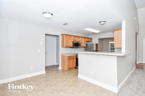 A kitchen with a white counter and wooden cabinets.