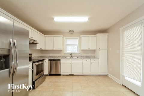 A kitchen with a refrigerator, oven, and sink.
