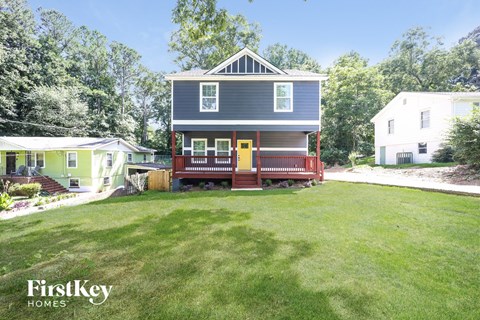 a blue house with a yellow door and a lawn