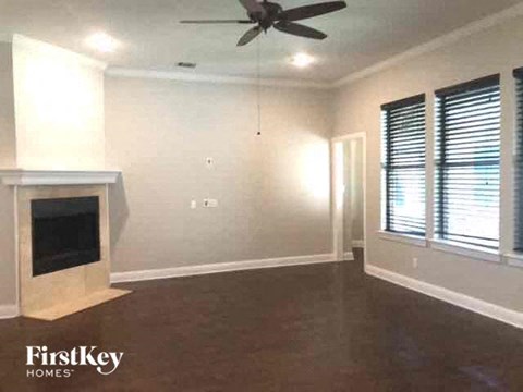 a living room with a fireplace and a ceiling fan