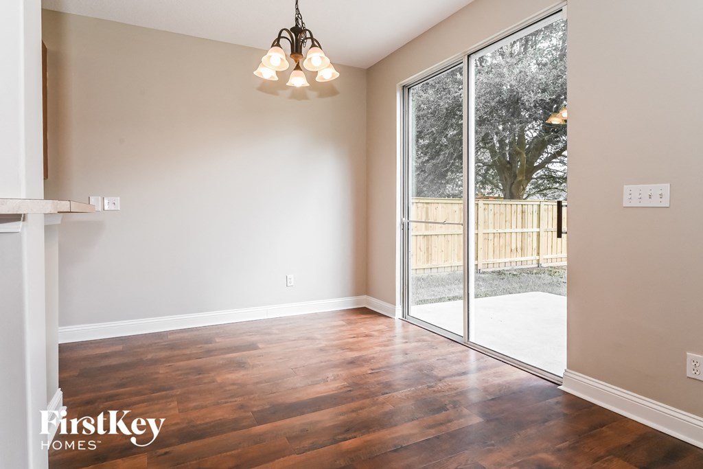 an empty living room with a sliding glass door to the backyard