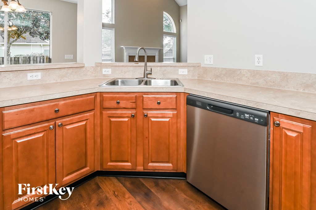 a kitchen with wooden cabinets and a stainless steel dishwasher