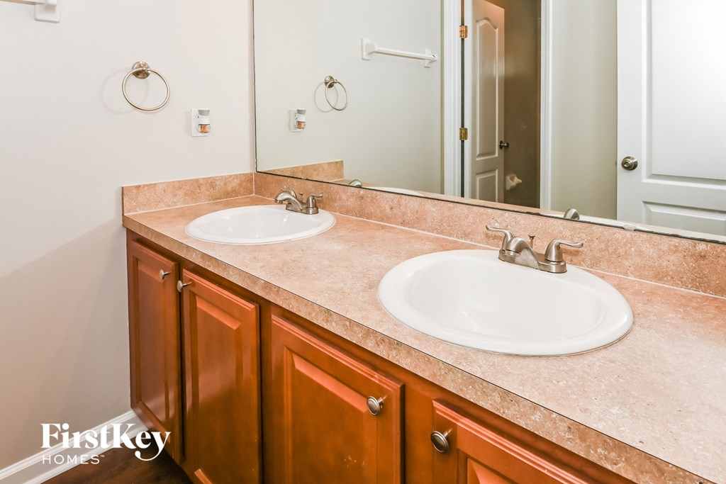 a bathroom with two sinks and a mirror