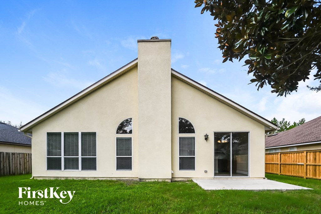 the front of a white house with windows and a chimney