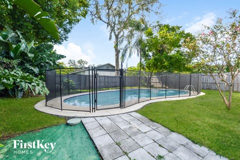 a swimming pool with a fence around it in a backyard