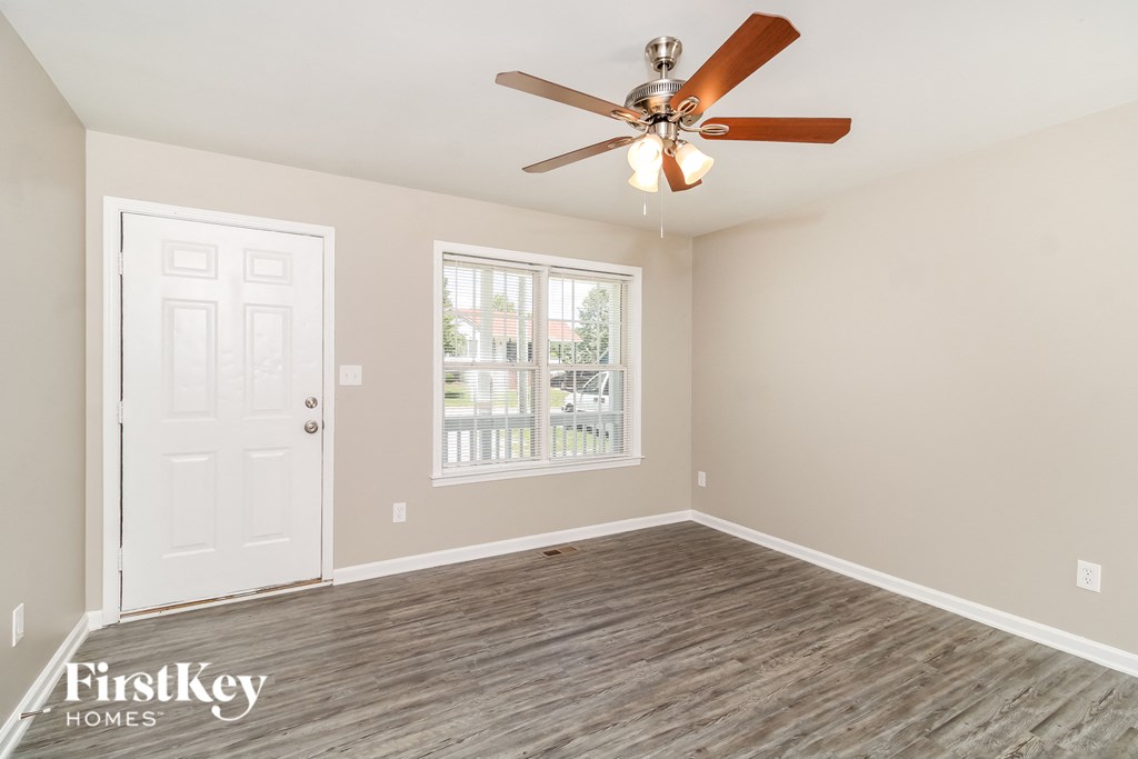 A room with a ceiling fan and a door leading to a balcony.