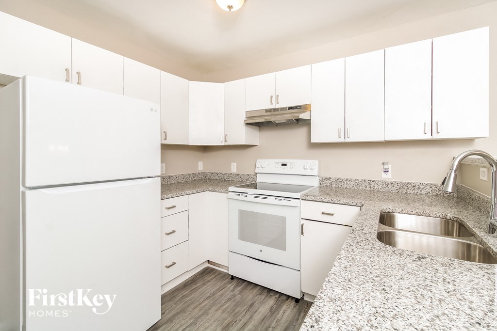 A kitchen with white appliances and cabinets.