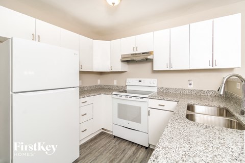 A kitchen with white appliances and cabinets.