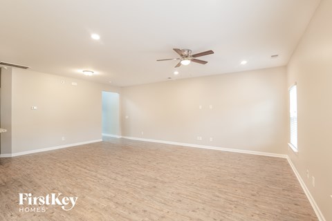 a empty living room with a ceiling fan