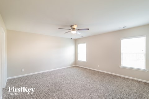 a bedroom with carpet and a ceiling fan