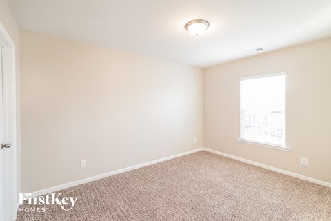 a spacious room with carpet and a window