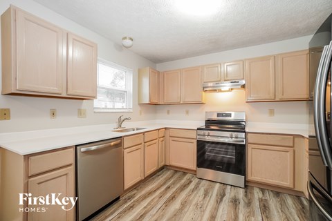 A kitchen with wooden cabinets and a stainless steel oven.