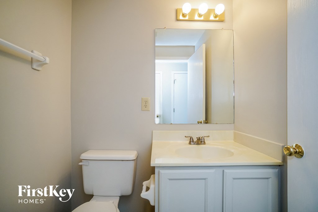 a bathroom with a sink toilet and a mirror