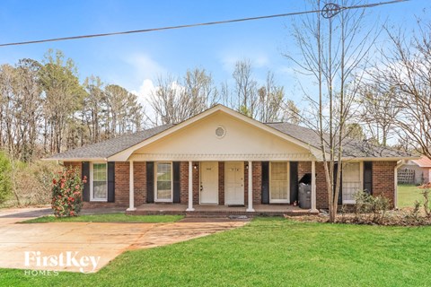 A house with a front porch and a lawn.