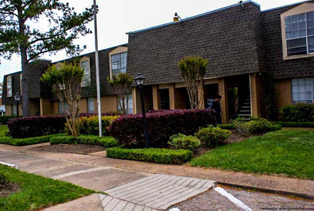 an apartment building with a walkway in front of it