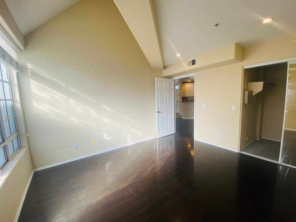 an empty living room with wood flooring and white walls