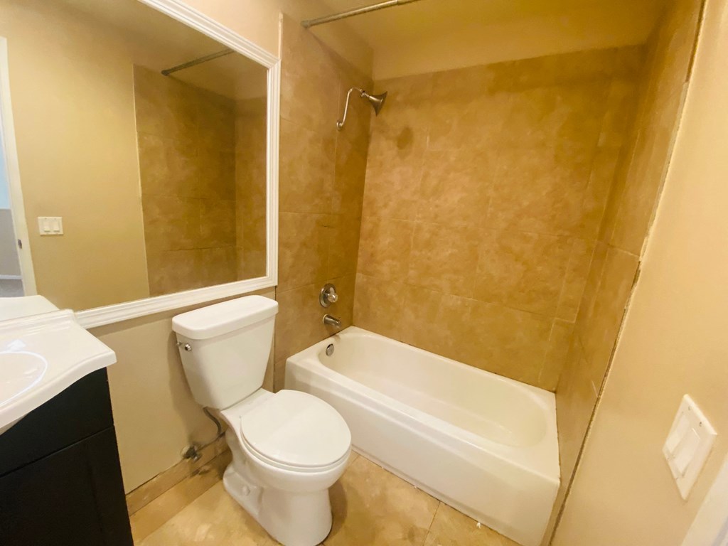 a bathroom with a toilet and a tub and a sink