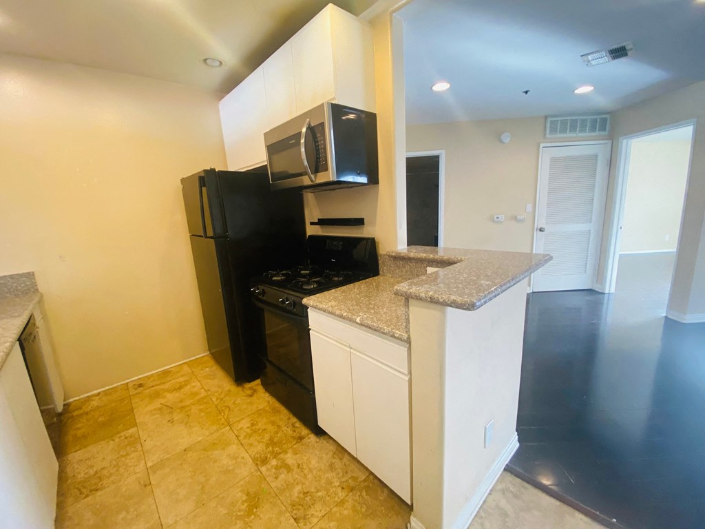 a kitchen with a stove and a refrigerator and a microwave