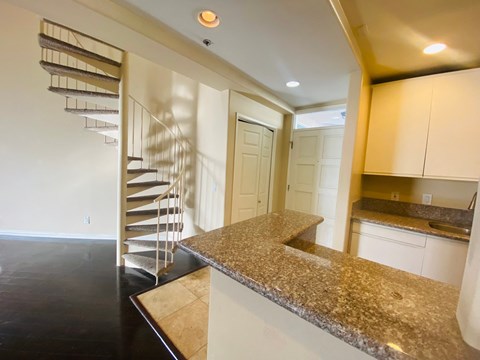 a view of a kitchen with a marble counter top and a staircase