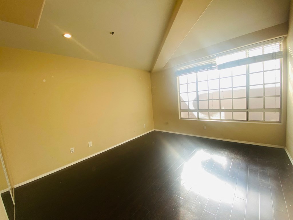 an empty room with yellow walls and a window