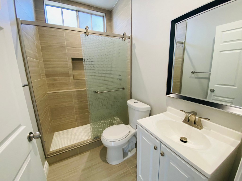 a small bathroom with a shower toilet and sink