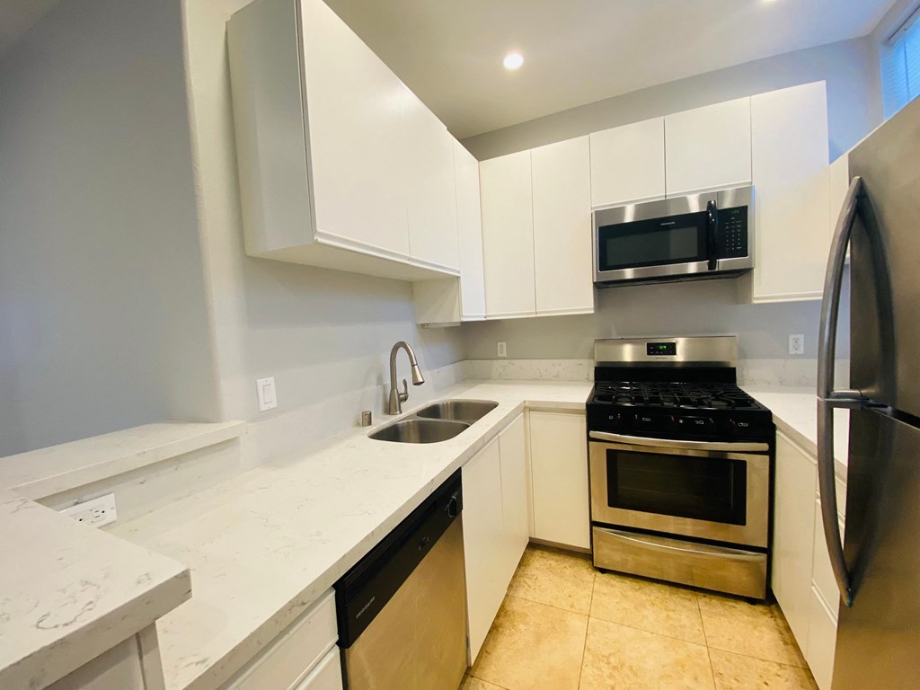 a kitchen with white cabinets and stainless steel appliances