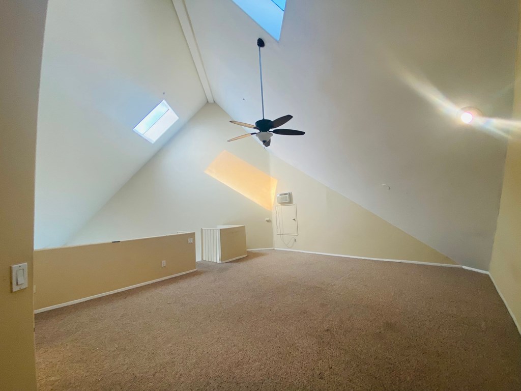 the attic of a home with a ceiling fan