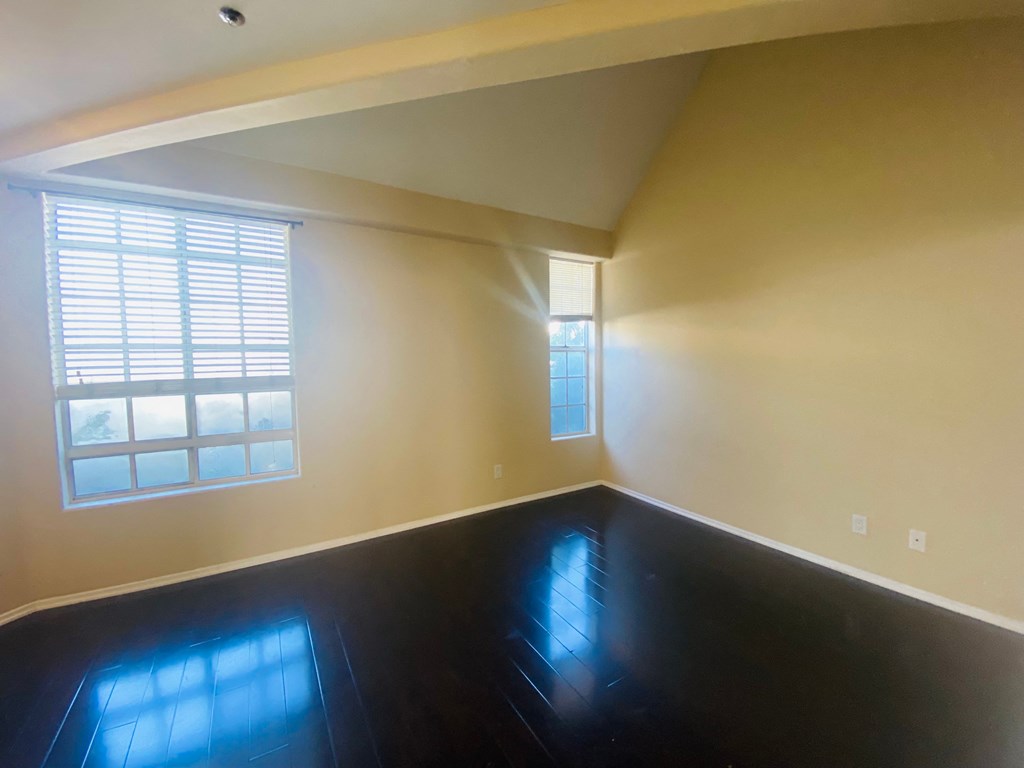 an empty room with a black floor and a window