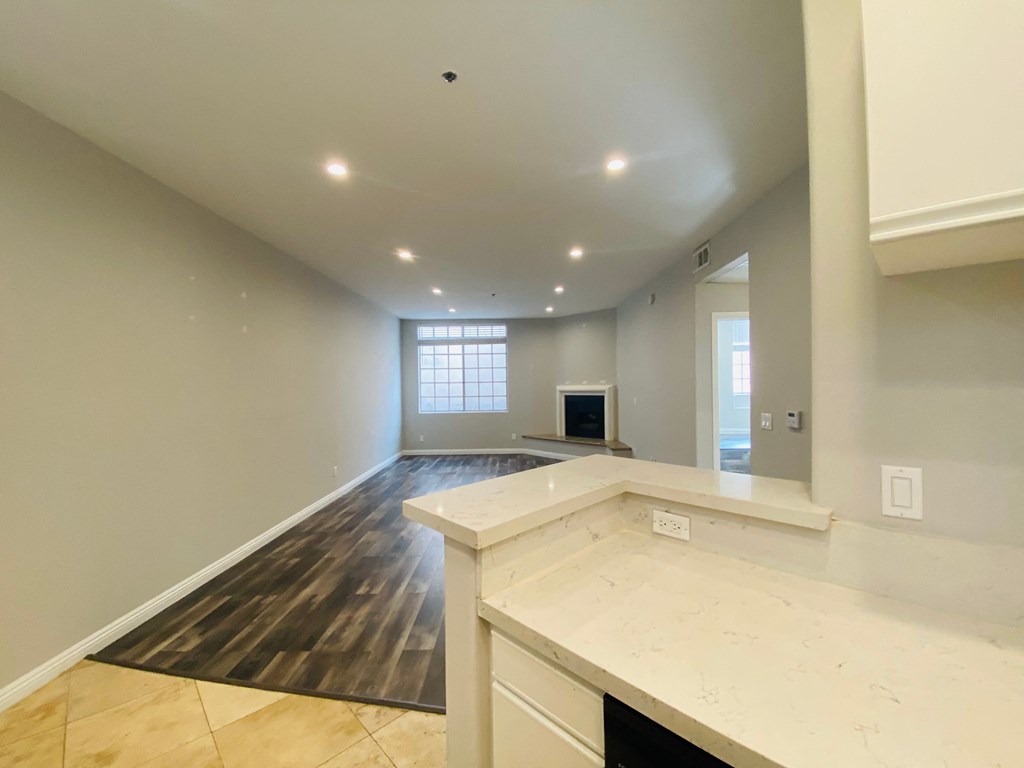 an empty living room and kitchen with a fireplace