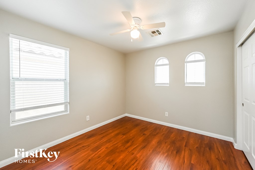 a living room with wood floors and a ceiling fan