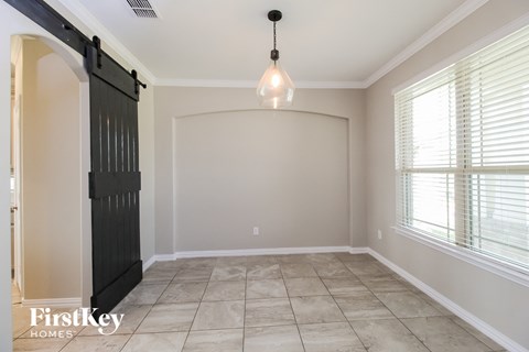 an empty dining room with a black barn door