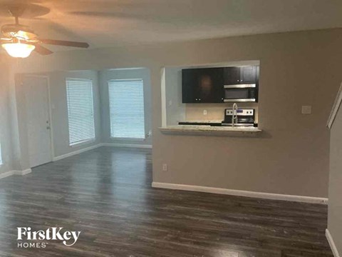 A living room with a television and a wood floor.