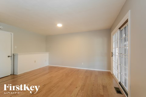 A room with wooden flooring and a sliding glass door.