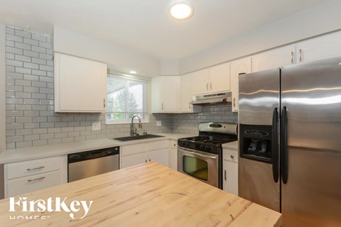 A kitchen with a wooden table and stainless steel appliances.