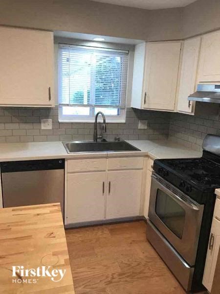 A kitchen with white cabinets and a black stove top.