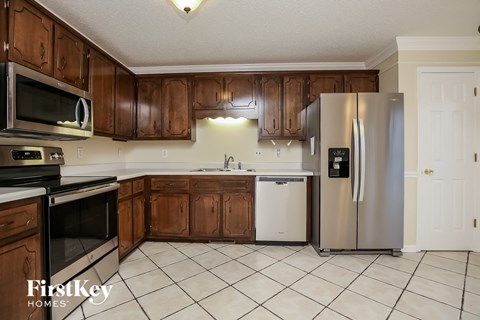 A kitchen with wooden cabinets and a white fridge.