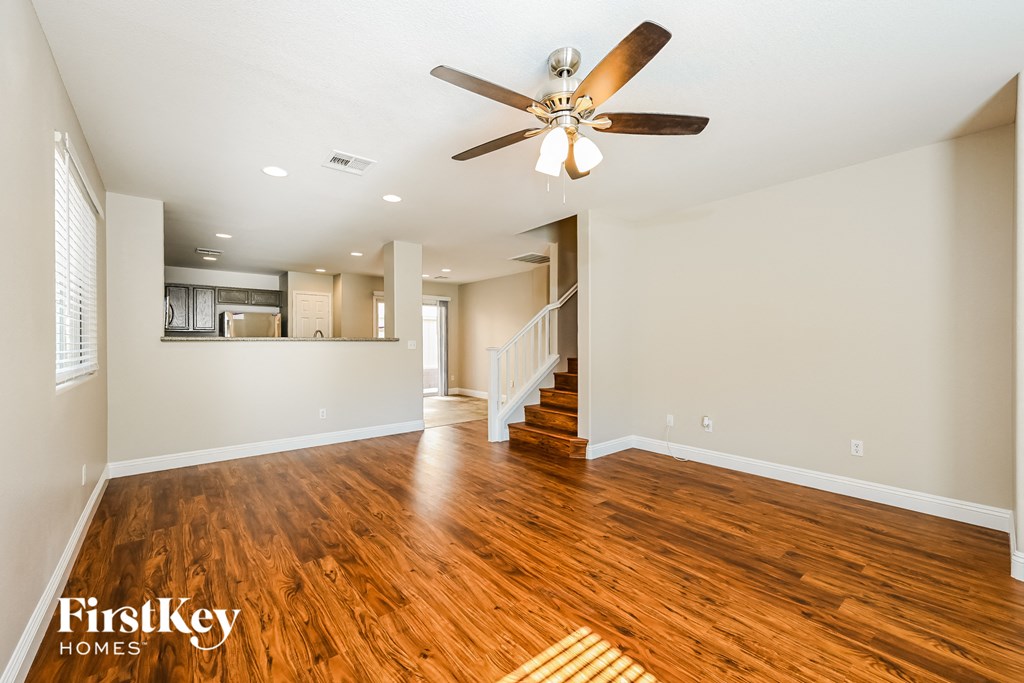 the living room and dining room with hardwood flooring and a ceiling fan