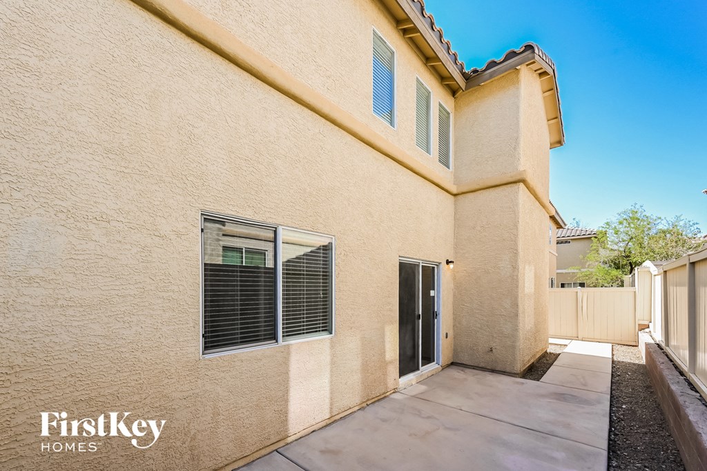 a beige house with a driveway and a glass door