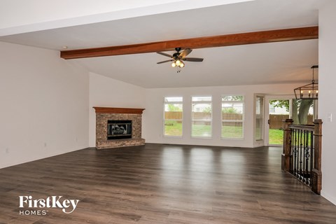 A spacious room with a fireplace and sliding glass doors.