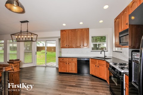 A kitchen with wooden cabinets and a black stove top oven.