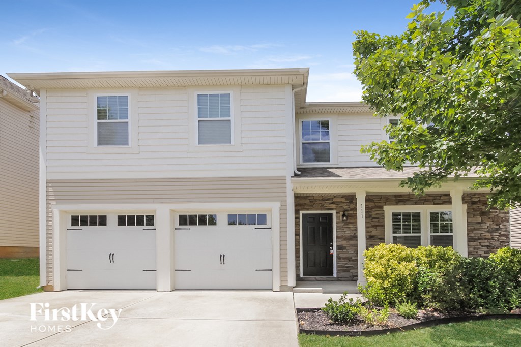 a white house with two garage doors